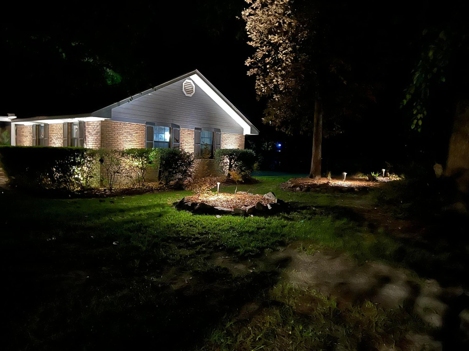 A house is lit up at night with a lot of lights in the yard. A house is lit up at night with a lot of lights in the yard.