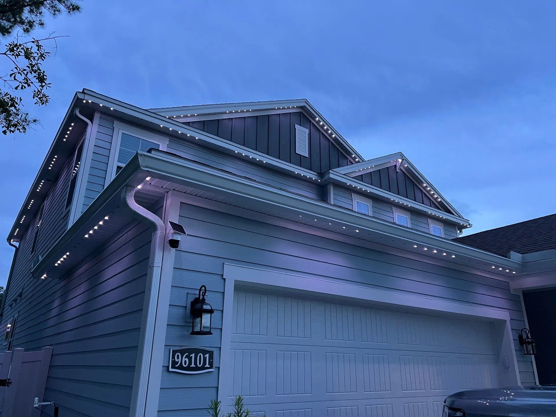 A blue house with featuring roof line lighting.