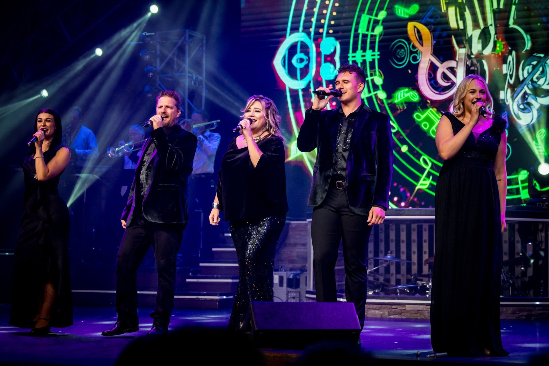 5 singers on stage in all black 