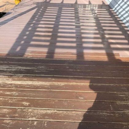 Wooden boardwalk with strong railing shadows cast across the planks in bright sunlight