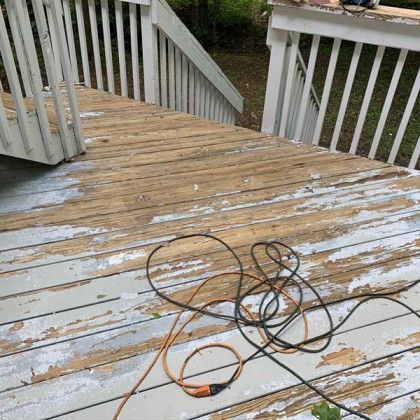 Snow-dusted wooden deck with tangled black extension cords near the railing