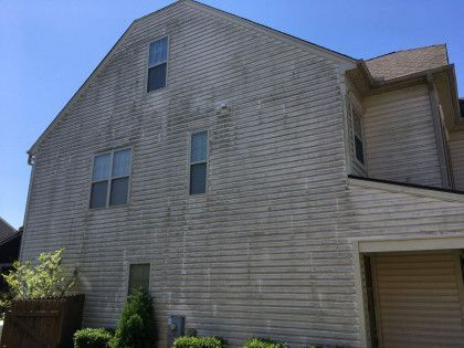 Gray shingled house exterior with multiple windows and a small covered entrance