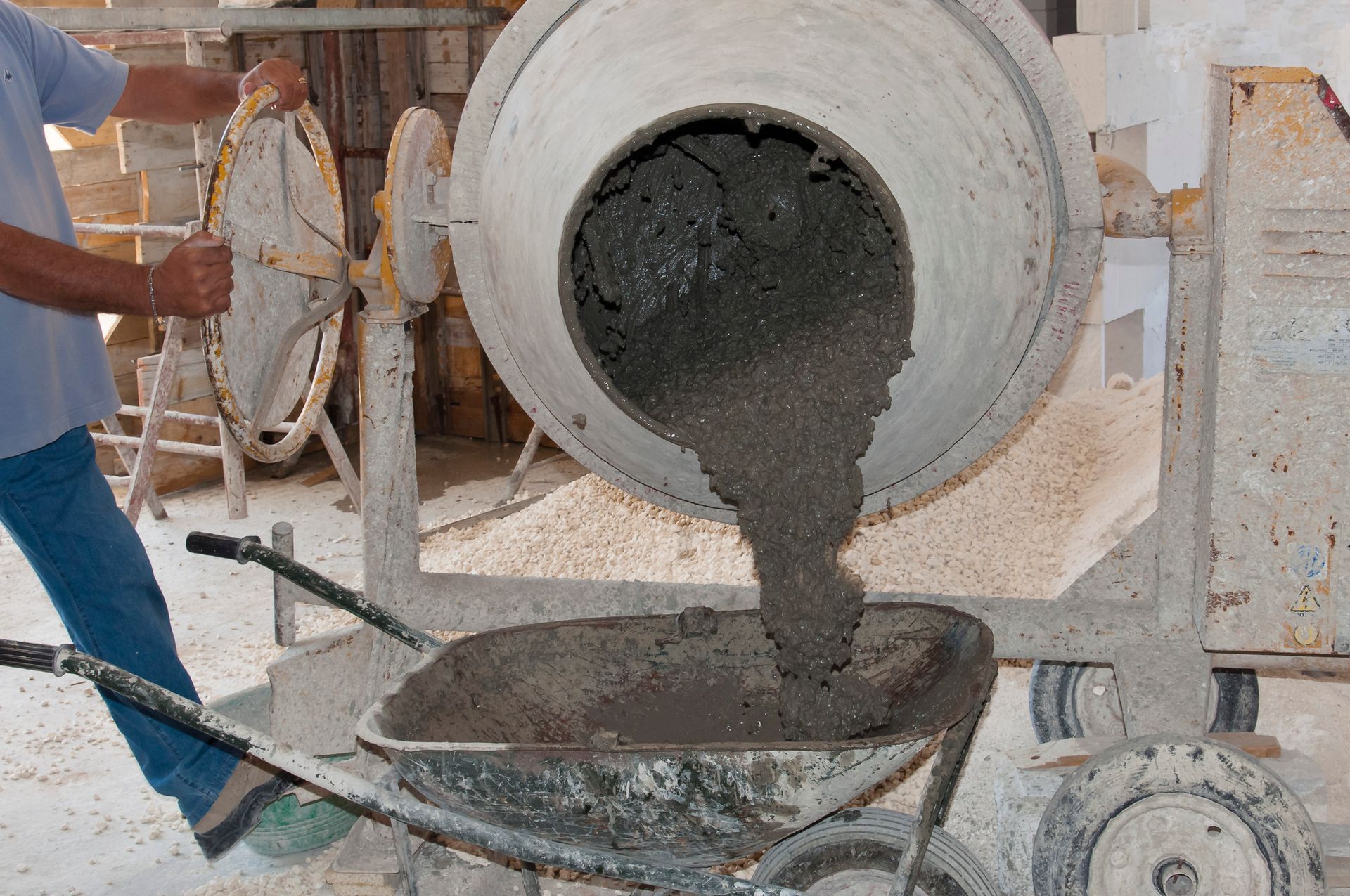 En una obra de construcción, se vierte hormigón desde una hormigonera a una carretilla.