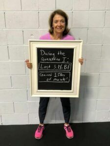 A woman is holding a framed chalkboard with a message on it.