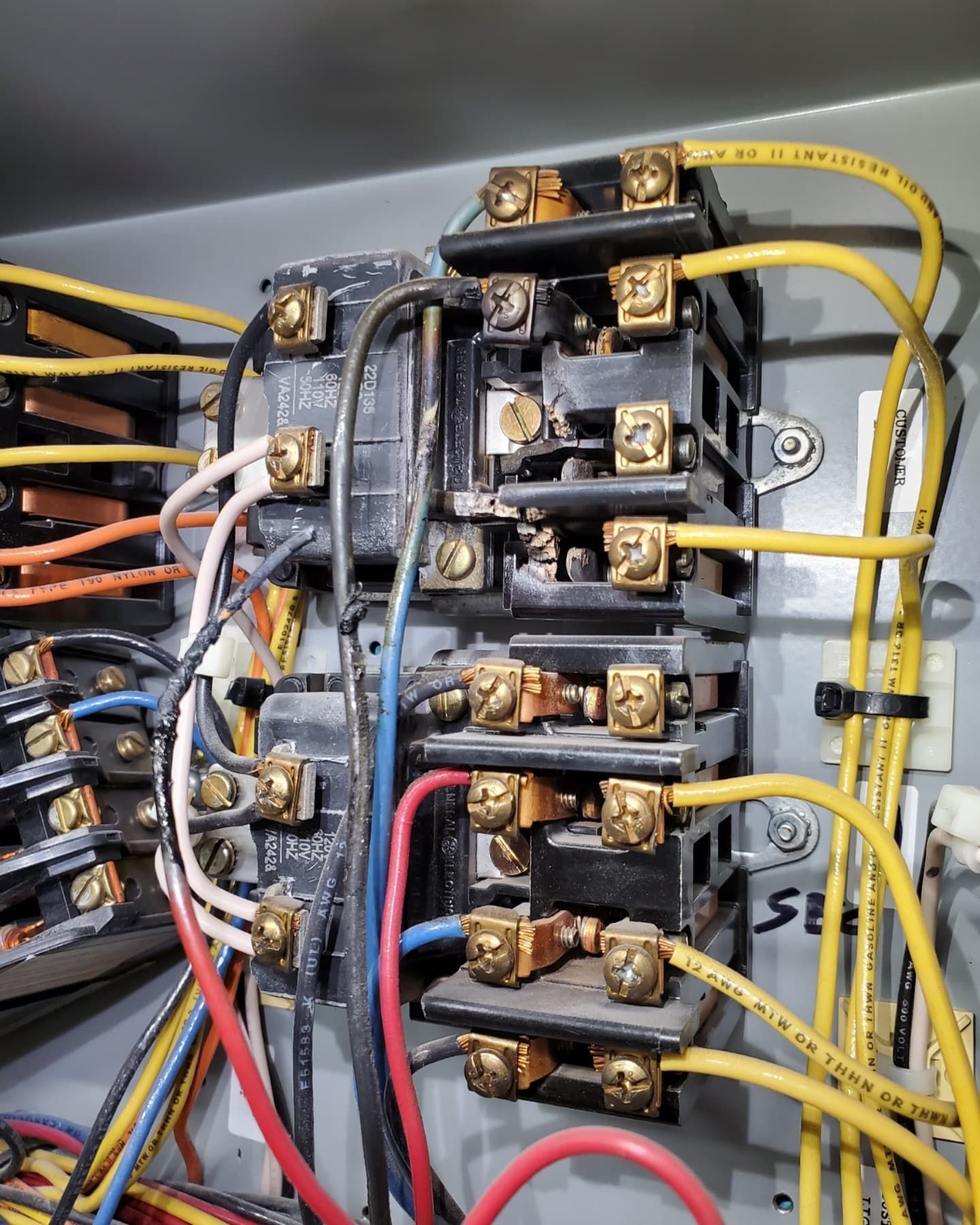 Electrical components with multiple wires connected to brass terminals.