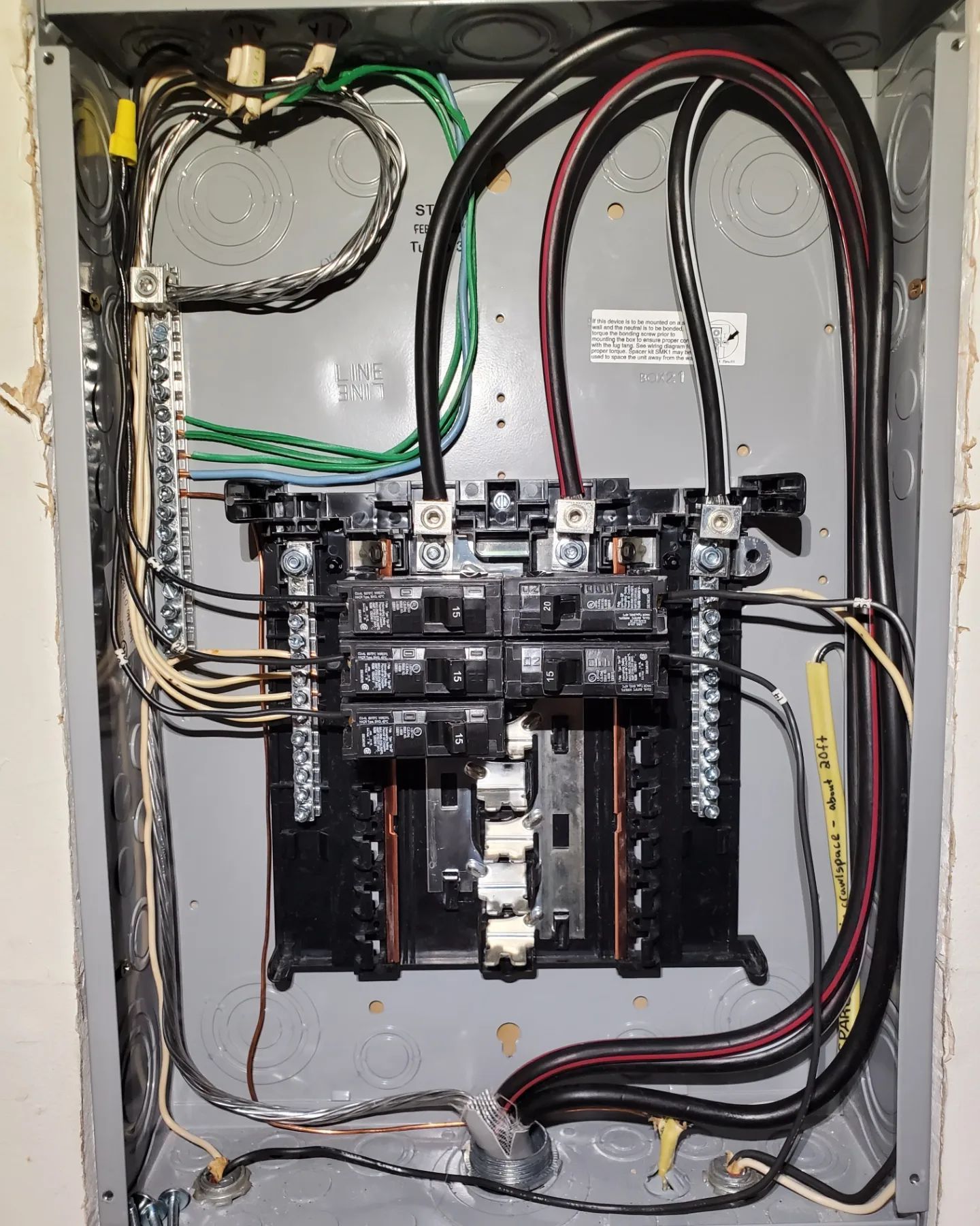 Electrical panel with wires and circuit breakers.