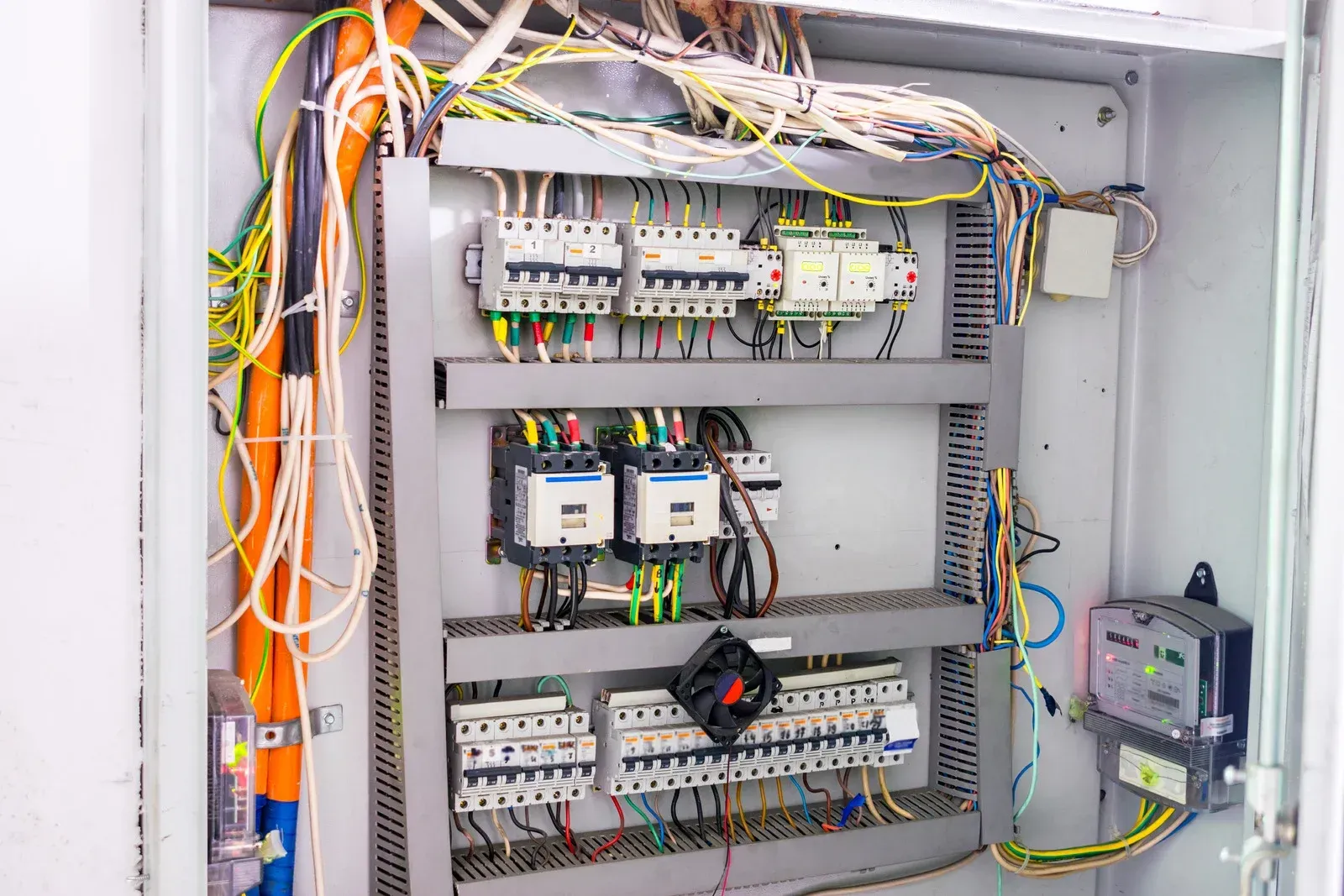 Electrical control panel with wires and circuit breakers.