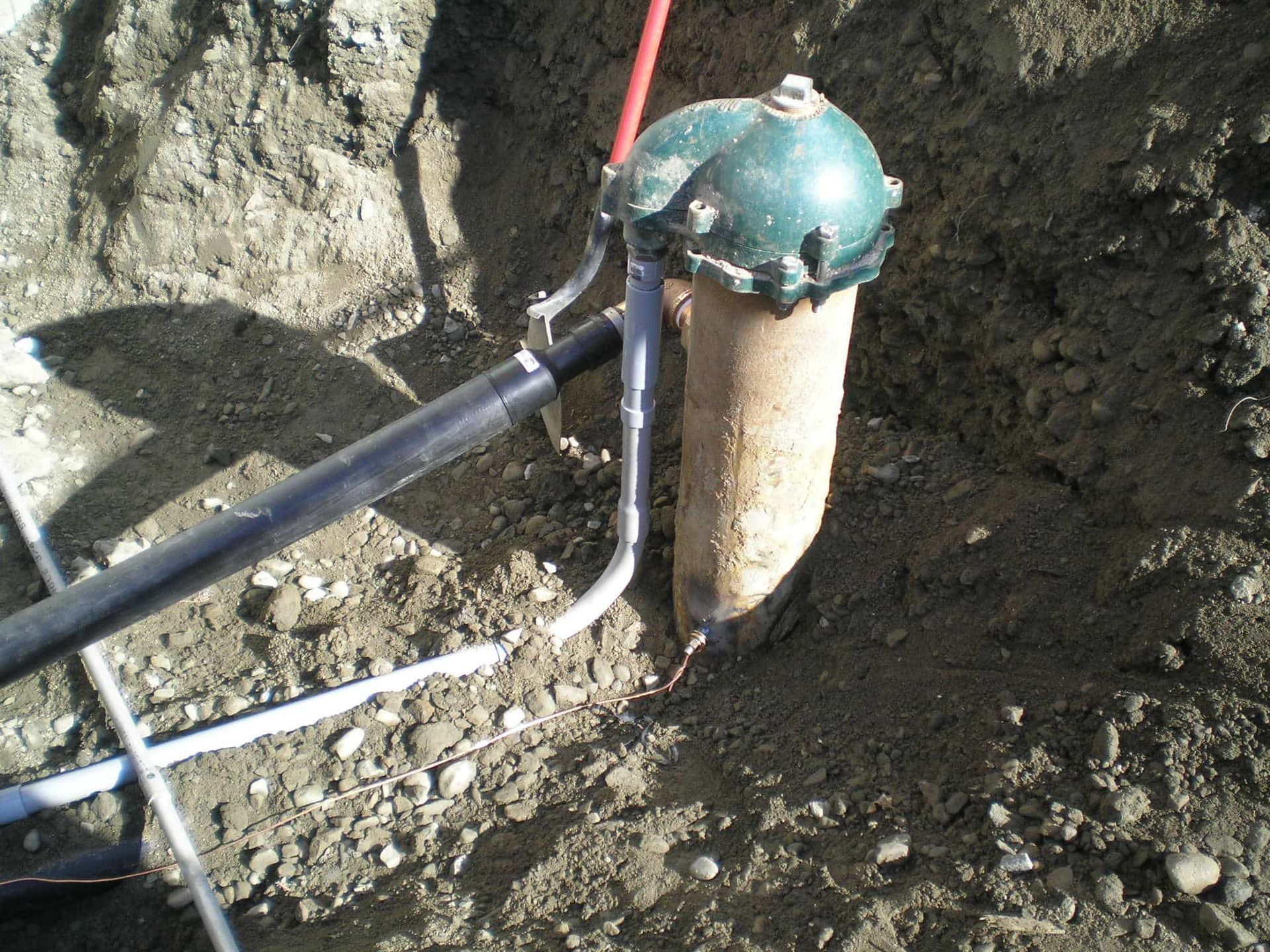 A hose is attached to a pipe in the dirt