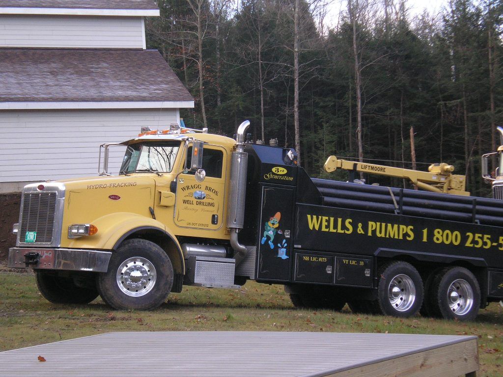 A wells and pumps truck is parked in front of a house from Wragg Brothers Well Drilling