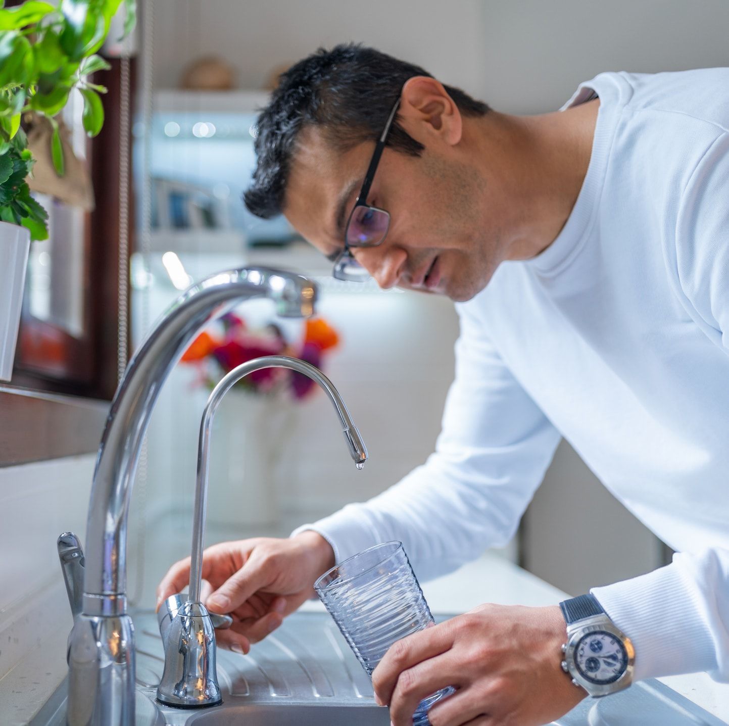 A person measuring water tank pressure with a pressure gauge.