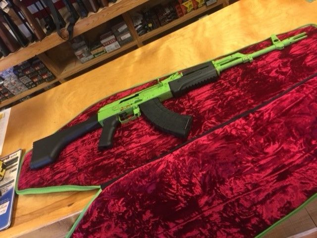 Black-and-green rifle on a red velvet display cloth in a store
