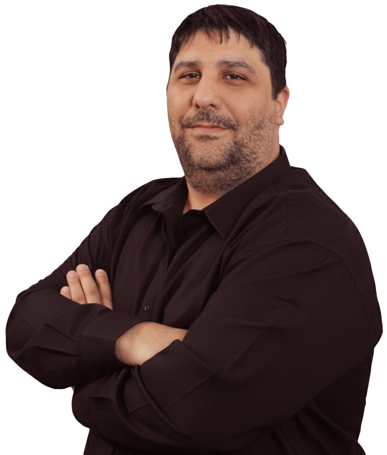 Hombre con los brazos cruzados, vestido con una camisa negra, sonríe, parece confiado.