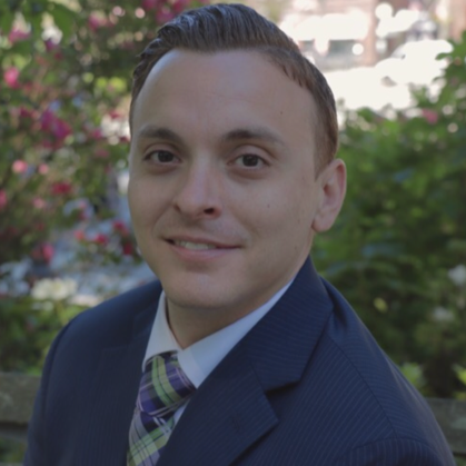 A man in a suit and tie is smiling for the camera