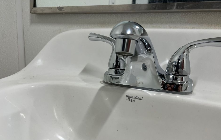 Chrome bathroom sink faucet with a single lever on a white porcelain sink