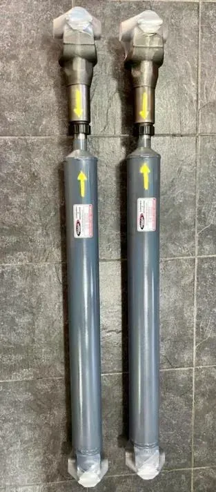 Dos tubos de metal gris con flechas amarillas, colocados en posición vertical contra una pared de azulejos.