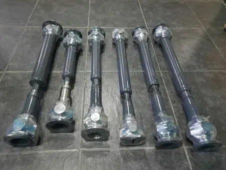 Seis largas varillas metálicas envueltas en plástico, colocadas una al lado de la otra sobre un suelo de baldosas.