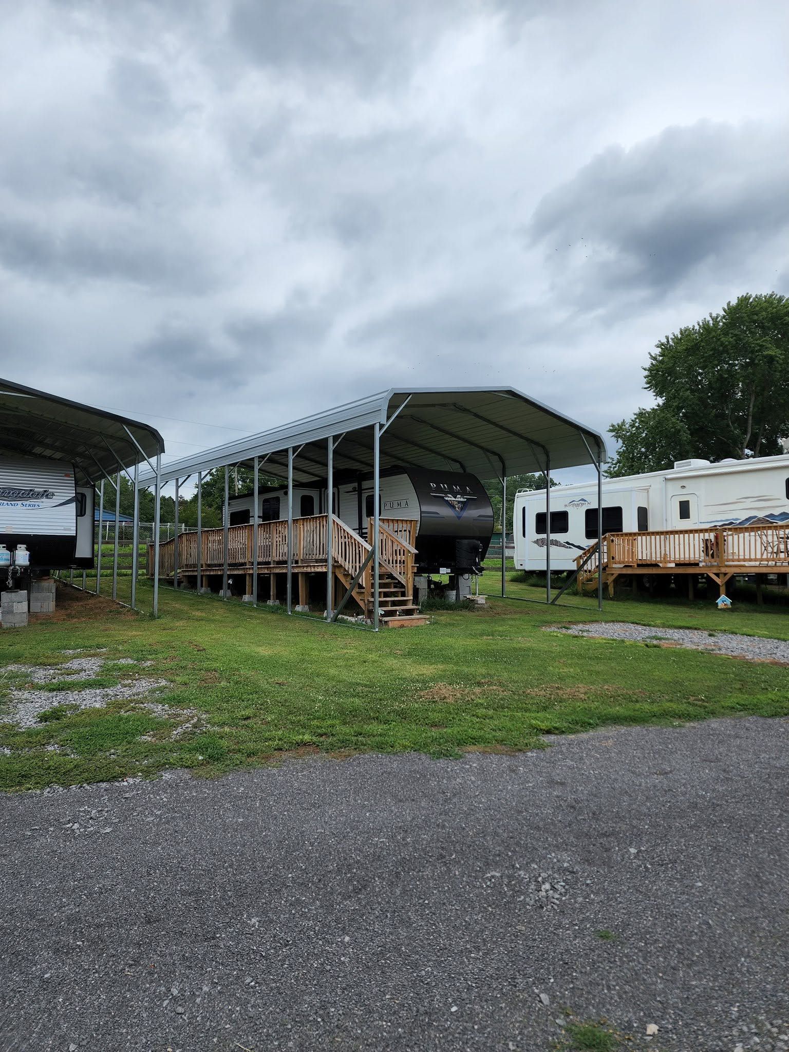 Covered storage lot with parked trailers and equipment under cloudy sky