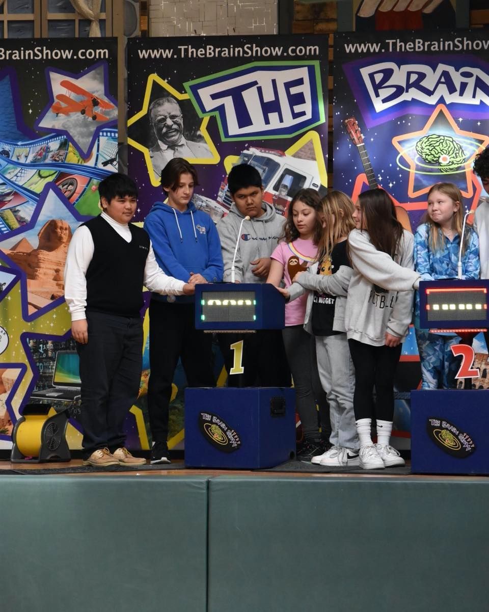 A group of people standing in front of a sign that says the brain show