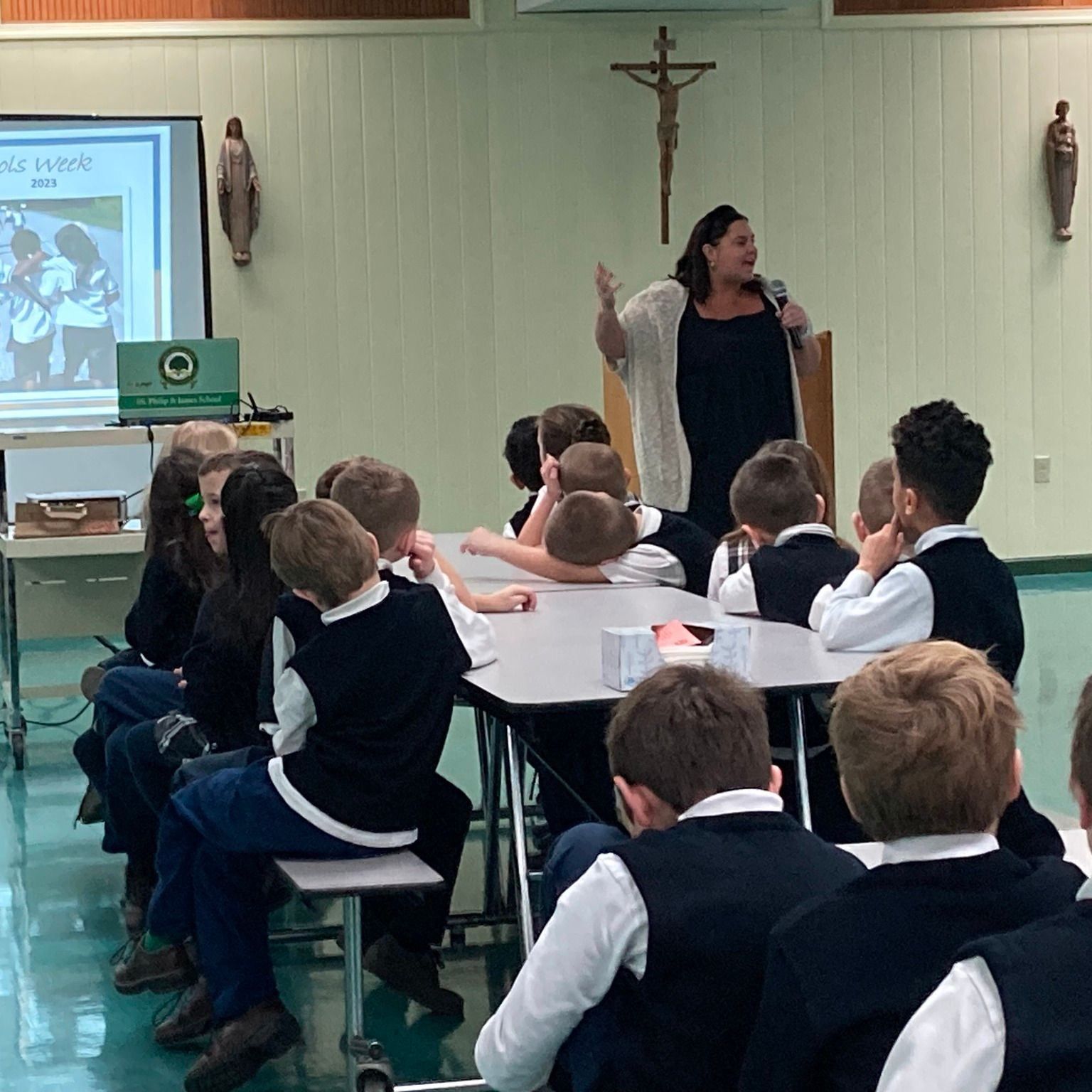 A woman is giving a presentation to a group of children