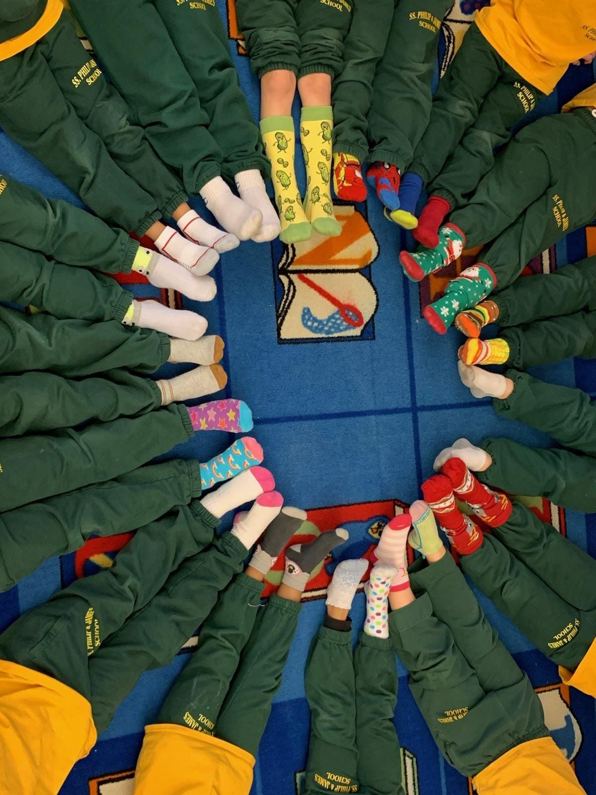 A group of children wearing different socks are standing in a circle