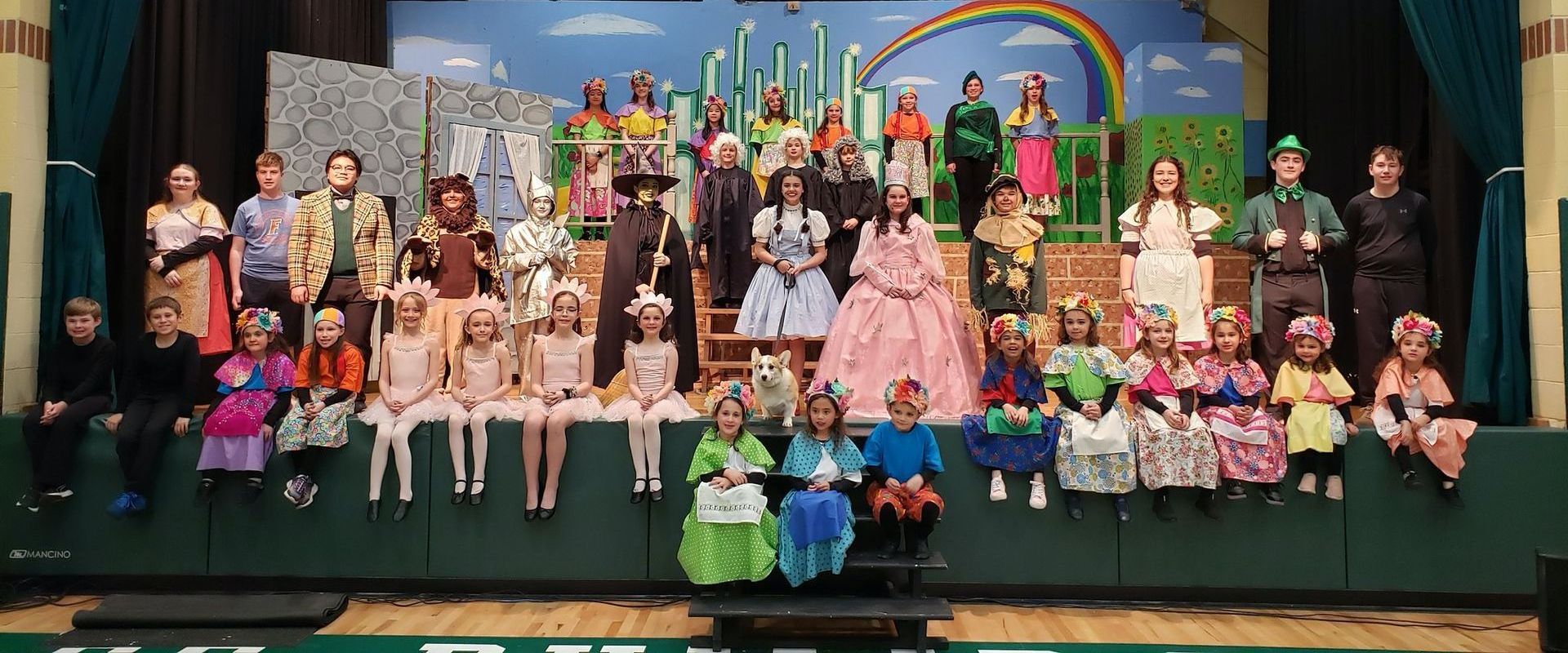 A large group of people are posing for a picture on a stage.