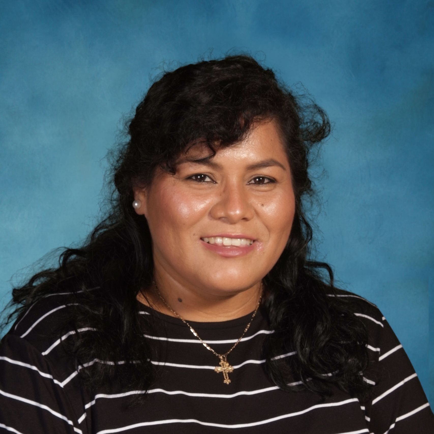 A woman wearing a black and white striped shirt and a cross necklace