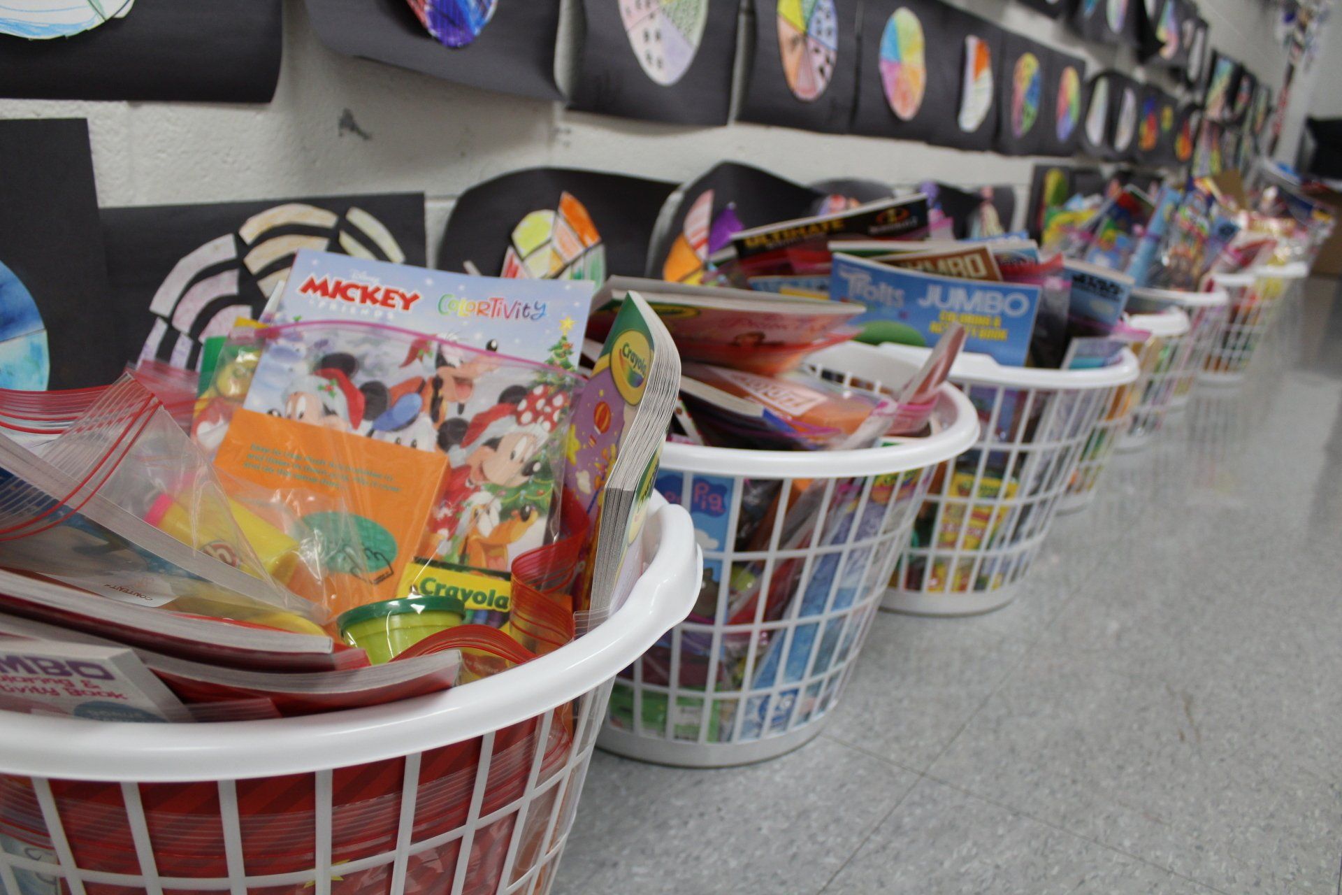 A row of laundry baskets filled with mickey mouse toys
