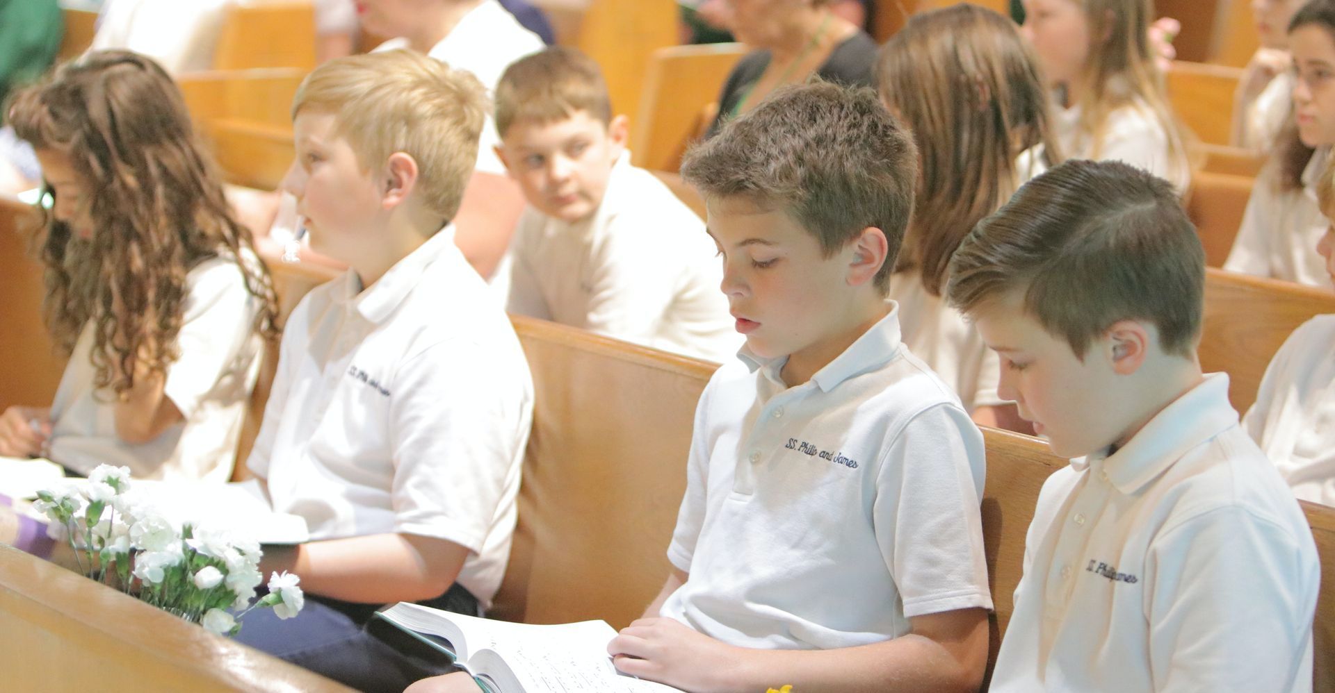A group of children are sitting in a church.