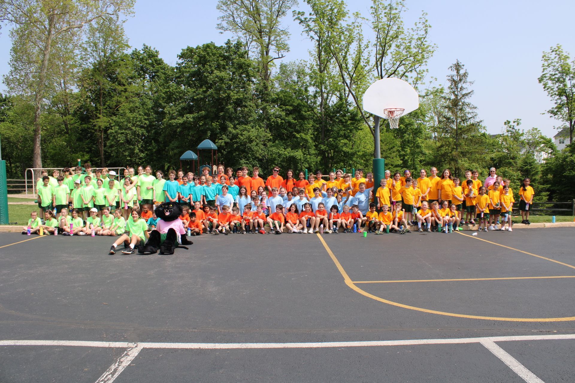 A large group of children are posing for a picture on a basketball court