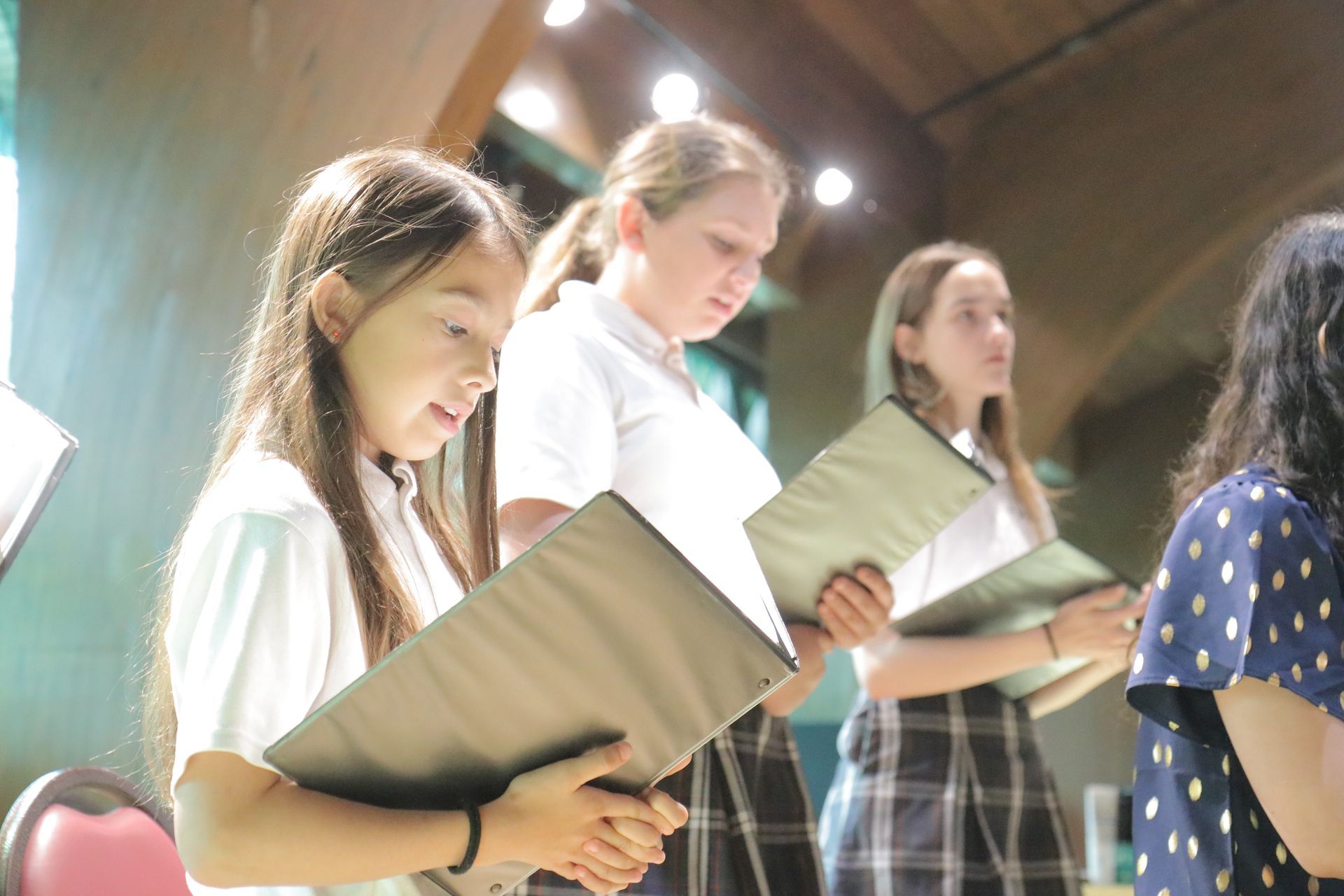 A group of young girls are singing in a choir.