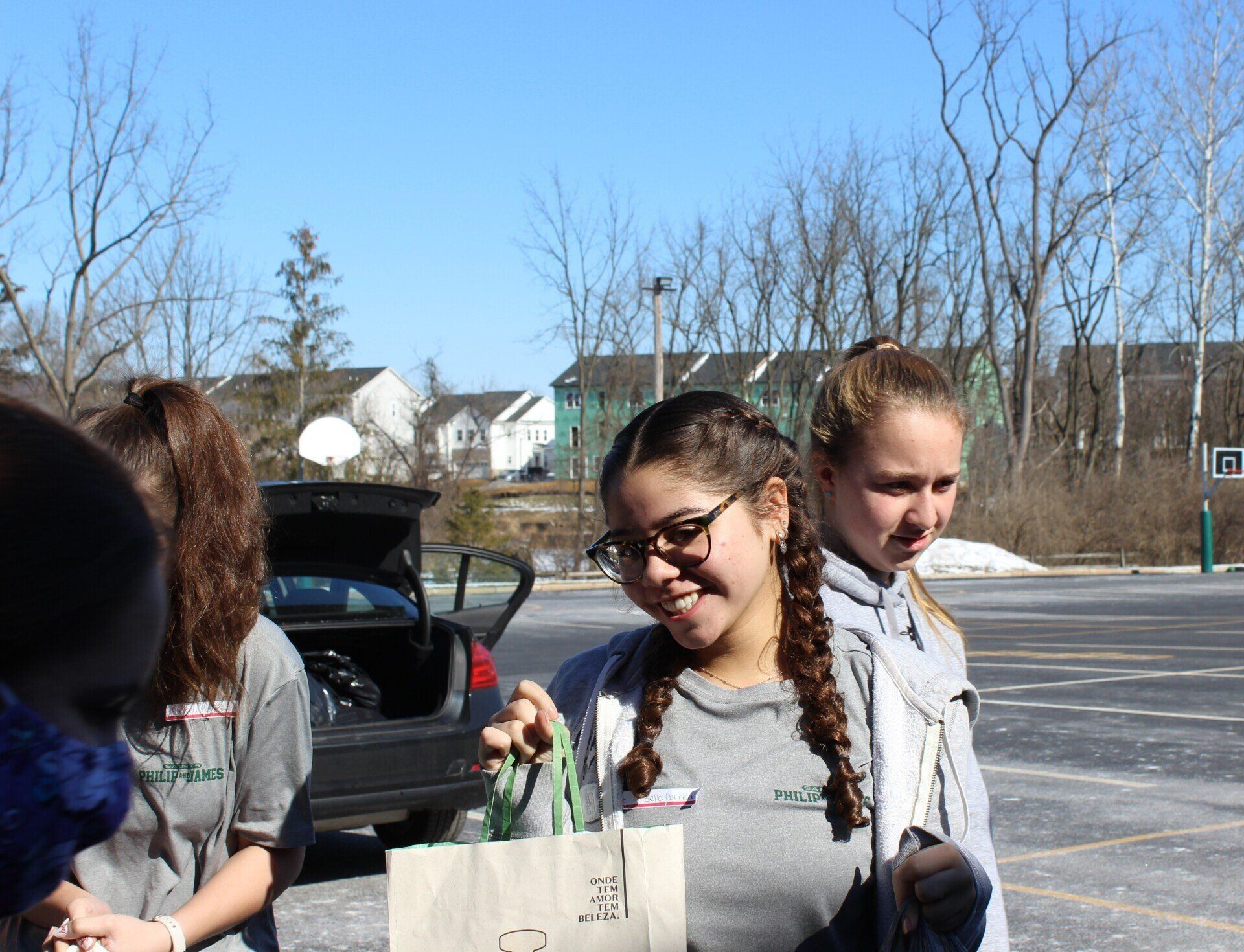 A group of young girls are standing in a parking lot