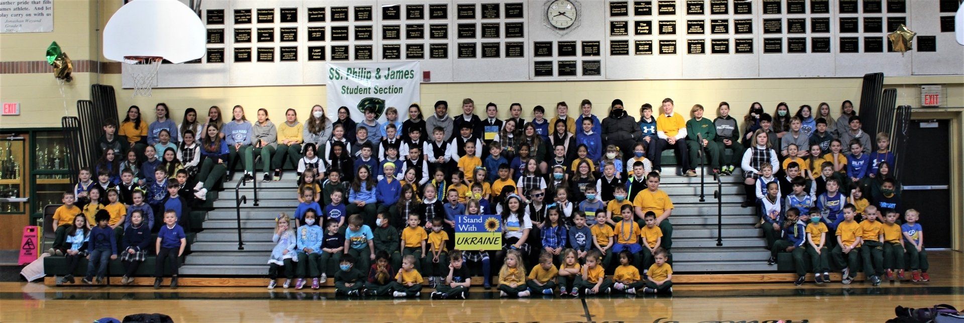 A large group of people are posing for a picture in a gym