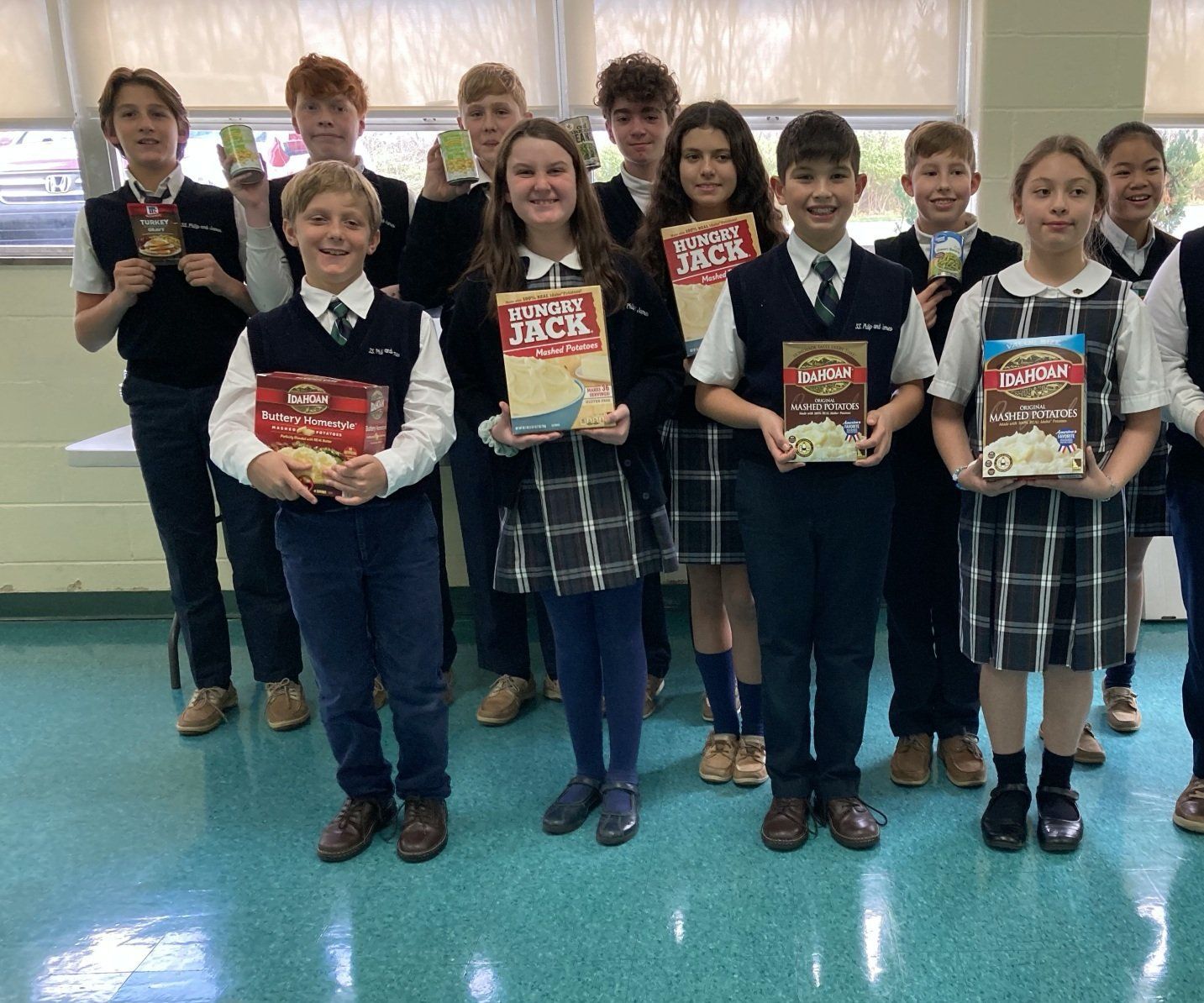 A group of children in school uniforms are posing for a picture holding cereal boxes.