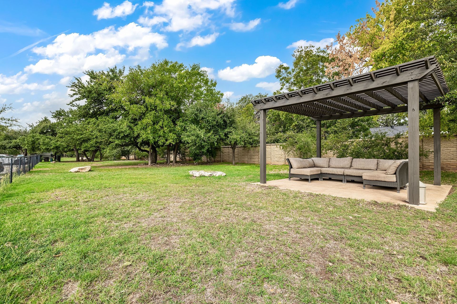 a backyard with a couch and a pergola