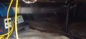 Dark crawlspace with a vent, cables, and a black pipe under a floorboard