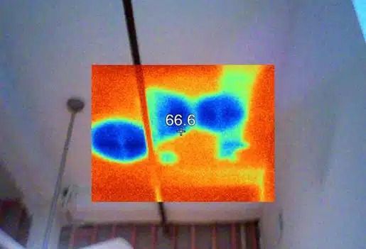 Thermal camera view of a room ceiling with a dark cable and colored heat map, labeled “66.6.”