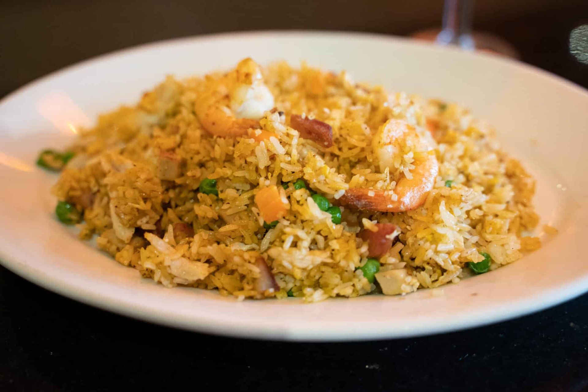 Plate of golden fried rice topped with a small dollop of sauce on a white dish