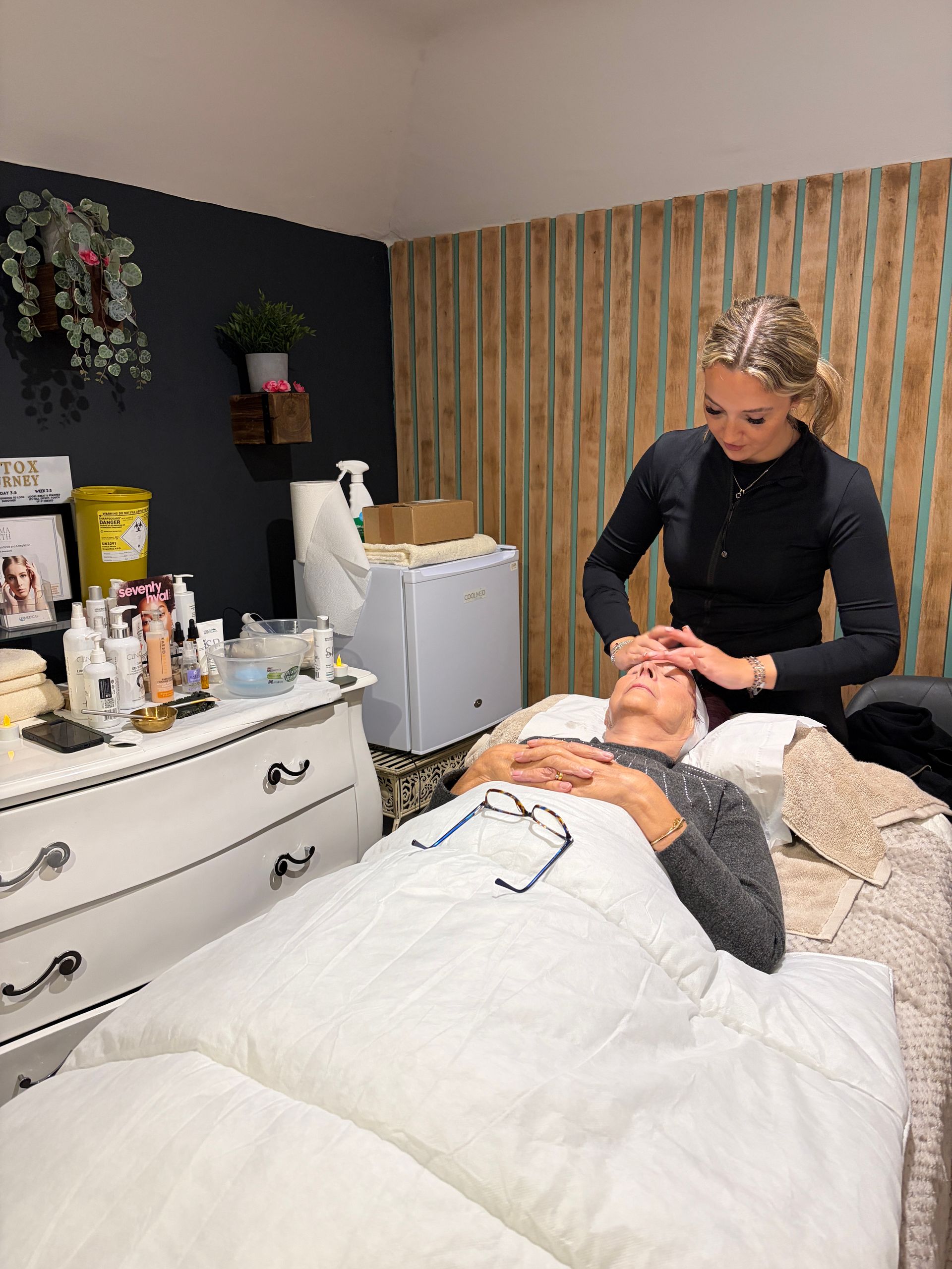 Therapist giving a client a facial massage in a treatment room at Claws Nail and Beauty