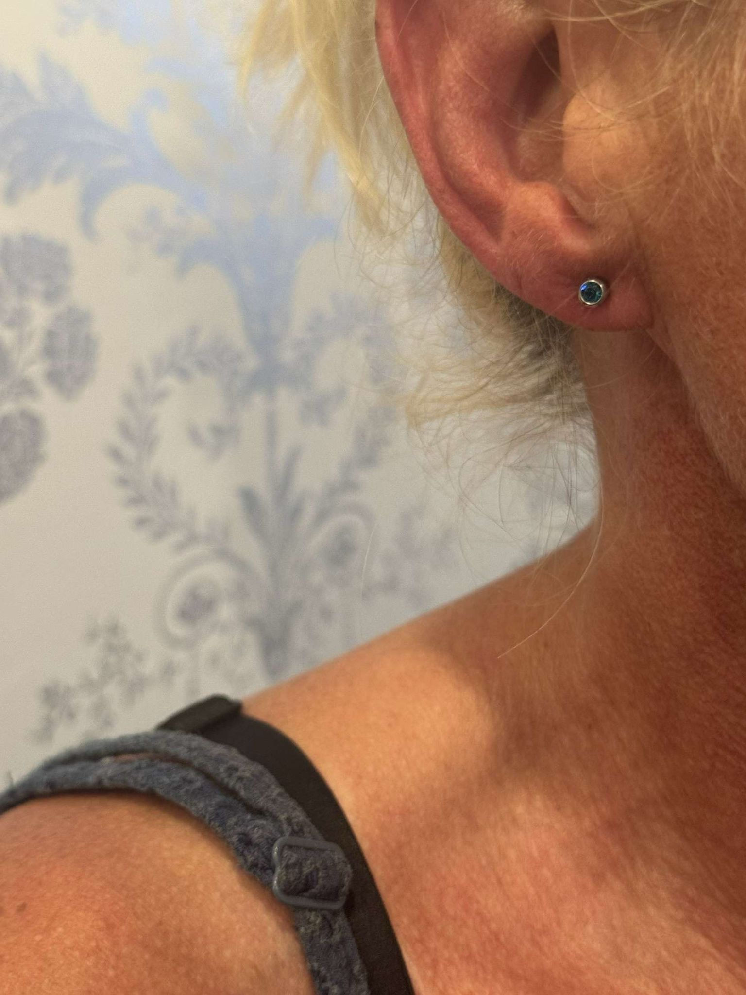 Client’s earlobe with a new blue stud earring after ear piercing at Claws Nail and Beauty in Daventry