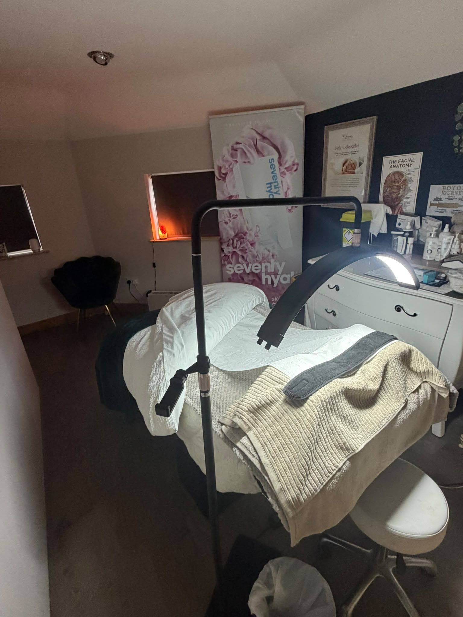 Aesthetics treatment room at Claws Nail and Beauty with a treatment bed, half-moon treatment light and a Seventy Hyal banner