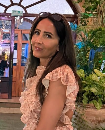 Nicola Mann at Claws Nail and Beauty, smiling with long dark hair and sunglasses on her head