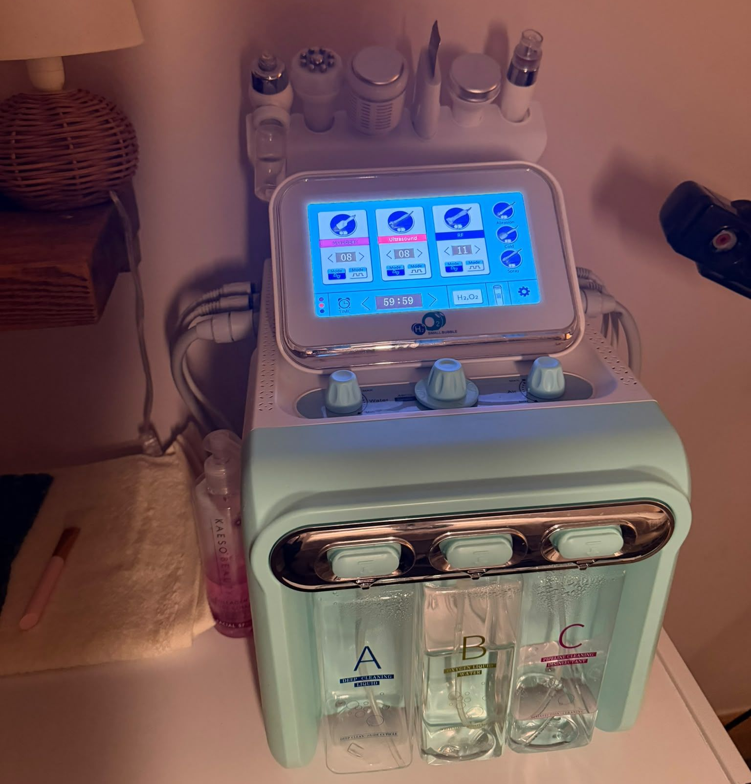H2O2 hydrating facial machine with touchscreen, handheld attachments and three solution bottles at Claws Nail and Beauty