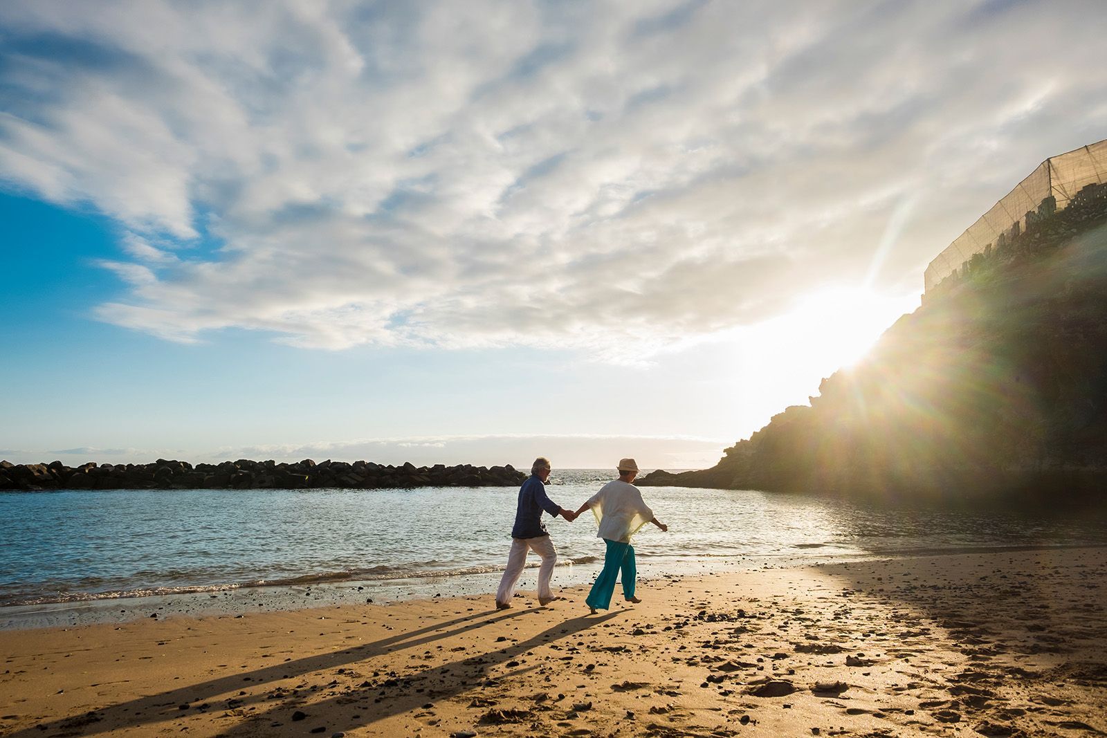 Mature, elderly couple walking on beach in Plantation, Sunrise, FL