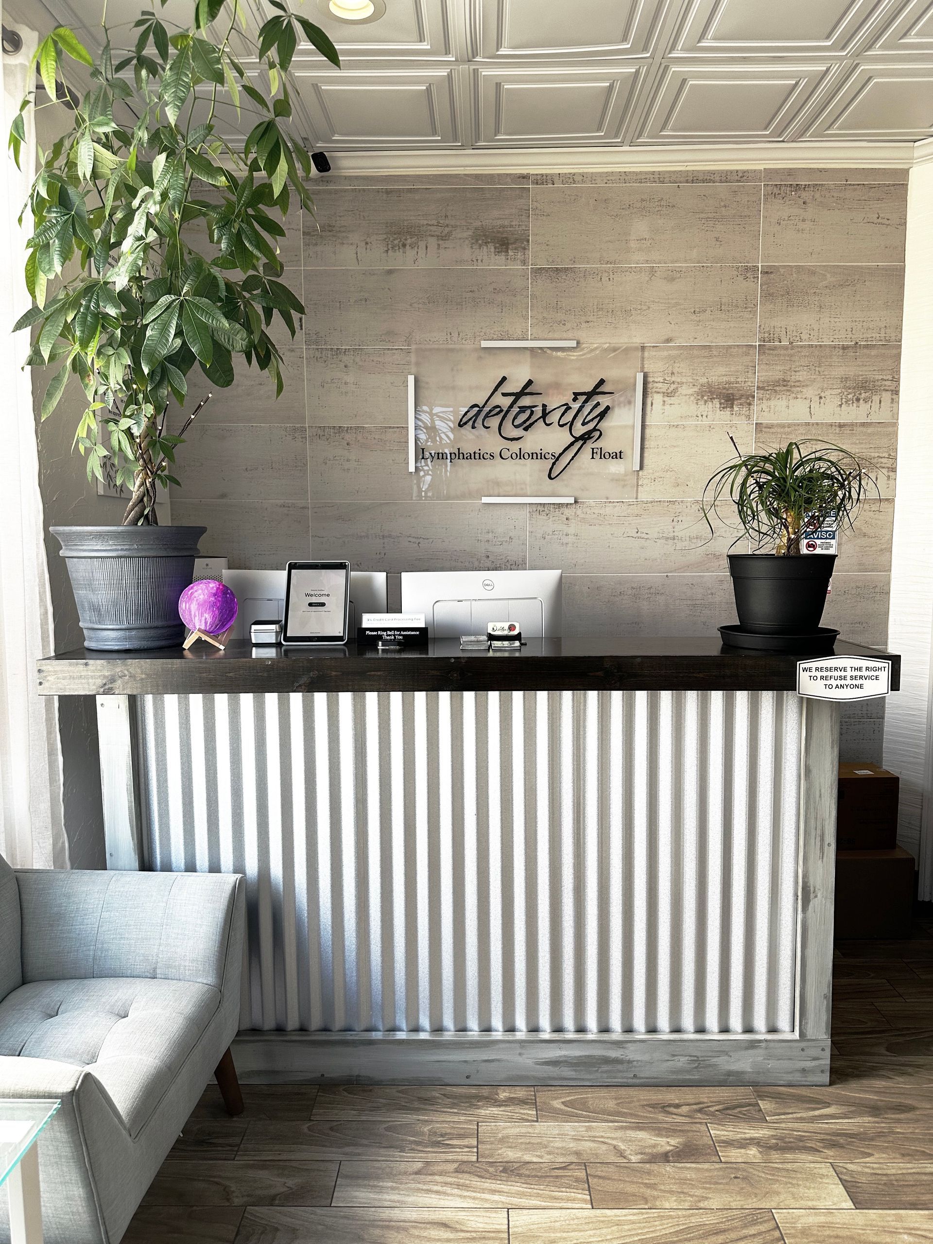 Detoxity Holistic MediSpa front desk with plants and a wood accent wall in The Woodlands, Texas