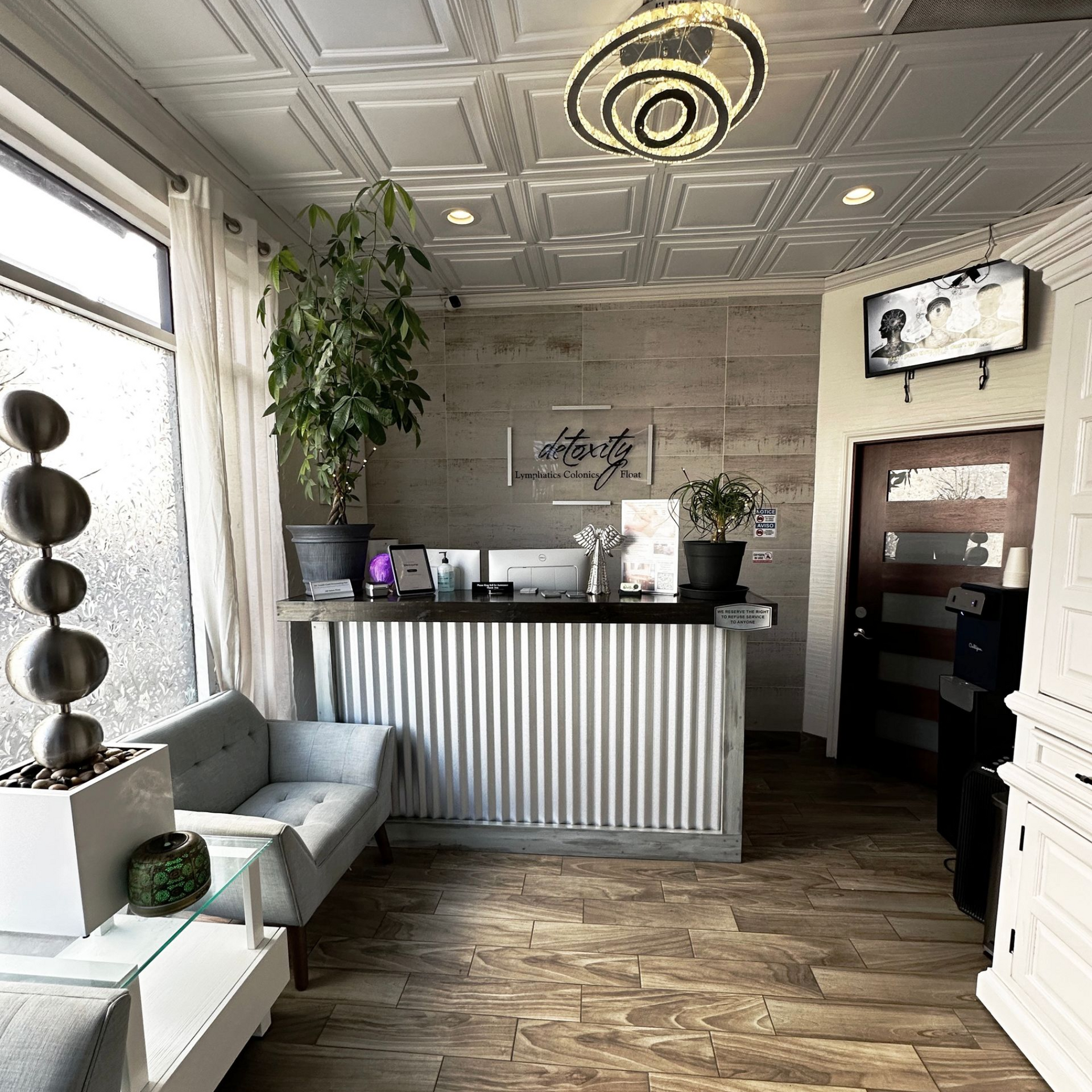 Bright, welcoming lobby with seating and plants at the front desk of Detoxity Holistic MediSpa in The Woodlands, Texas