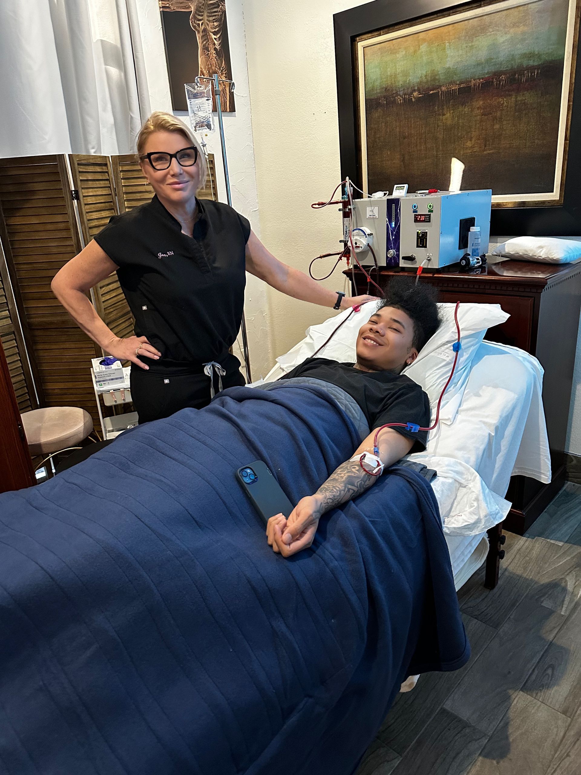 Smiling client resting under a blanket during a physician-supervised EBOO session at Detoxity Holistic MediSpa in Texas