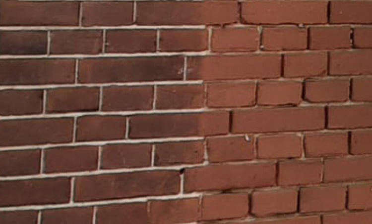 Close-up van een bakstenen muur met verweerde rode bakstenen en lichte voeglijnen.