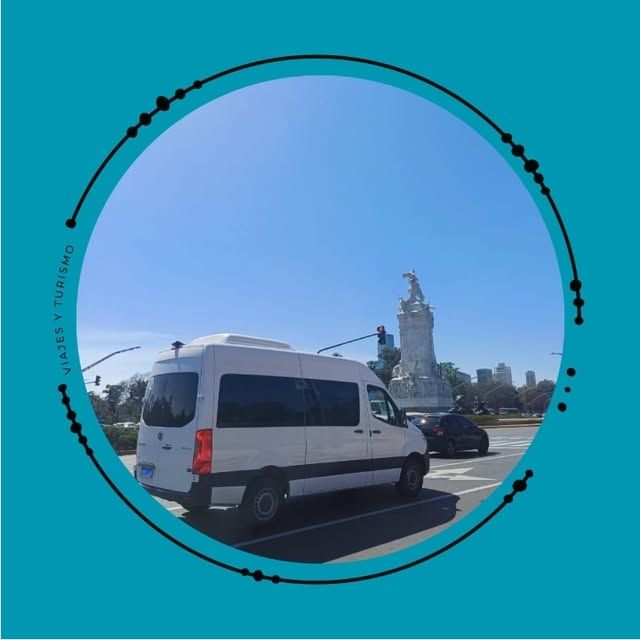 Una furgoneta blanca estacionada cerca de un monumento en un día soleado. Cielo azul.