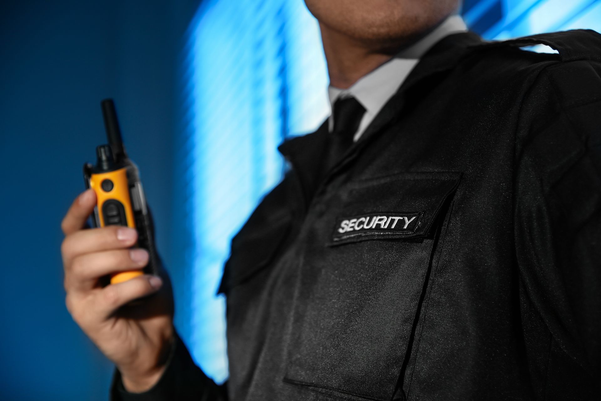Professional security guard with radio near window, showcasing security guard service expertise.