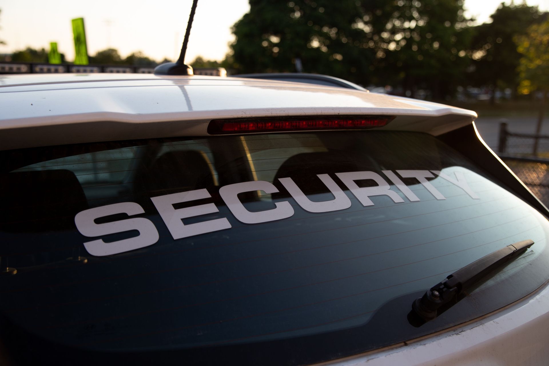 Security guard patrol services vehicle marked SECURITY parked outdoors at dusk.